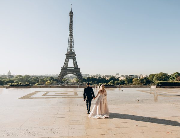 Woman and man walking in park in front of eiffel tower