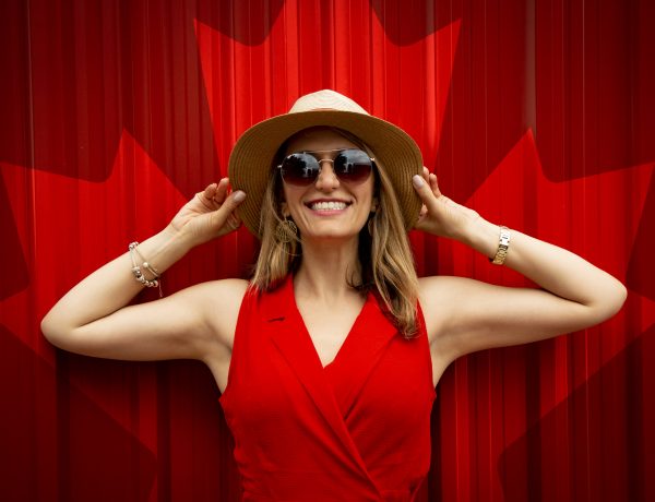 Woman in red sleeveless dress with canada flag printed background