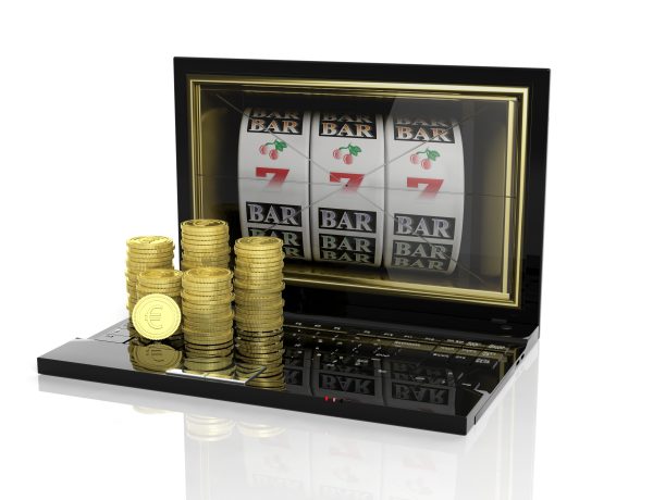 Stacks of golden Euro coins on laptop with 777 slots on screen, isolated on white background.