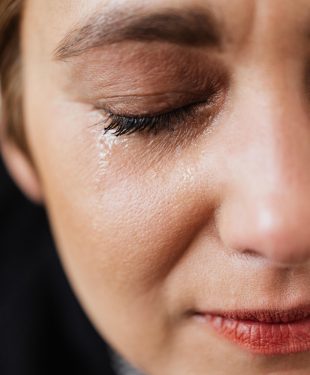 Lonely woman crying with closed eyes