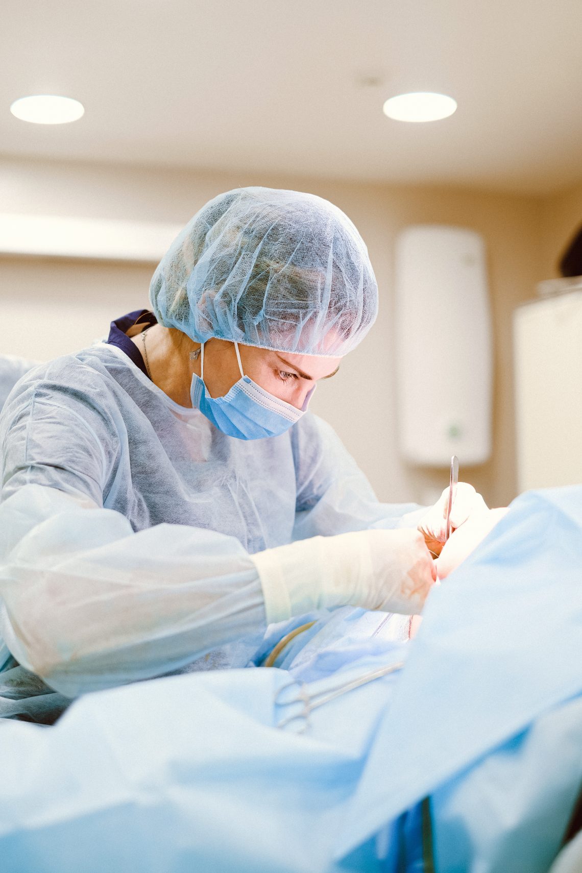 A woman wearing personal protective equipment holding medical apparatus
