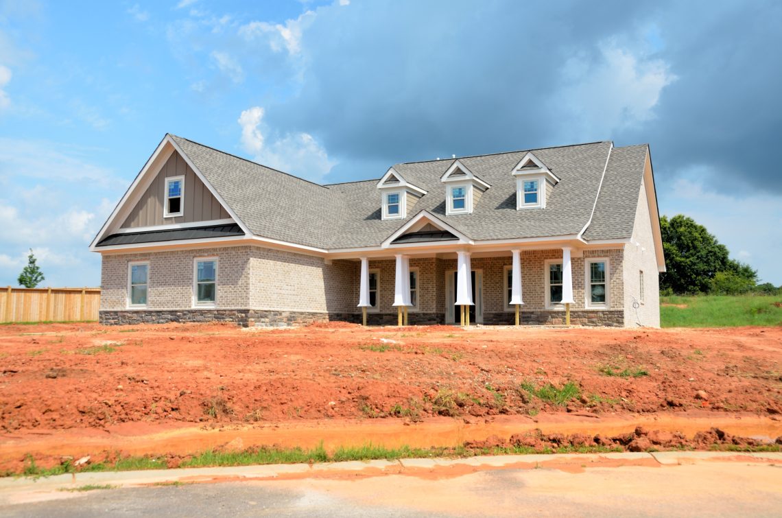 Gray bungalow house under blue and white cloudy sky