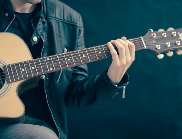Person holding brown and black guitar