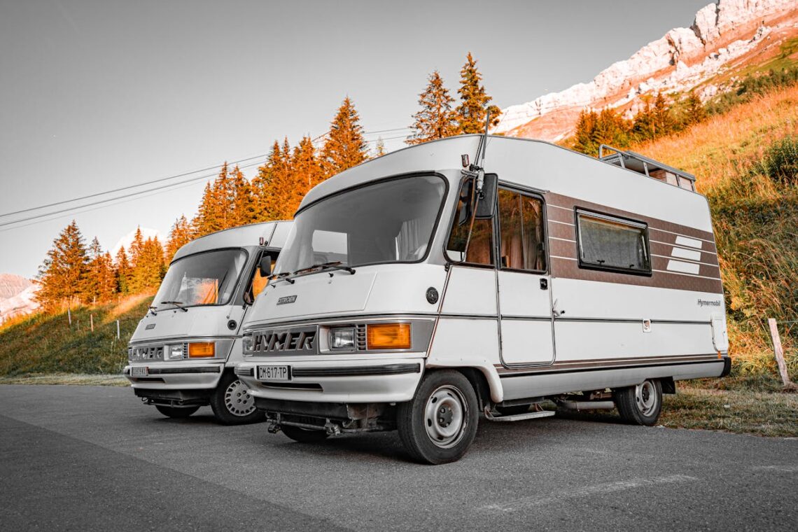 two vintage RVs parked on mountain road