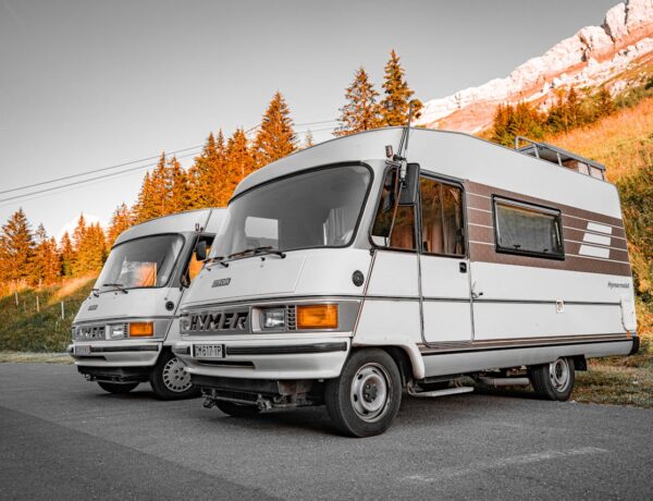 two vintage RVs parked on mountain road