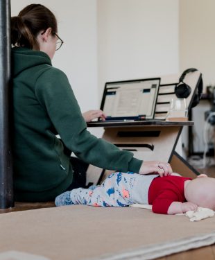 mother working from home - at flexible and height-adjustable desk with baby