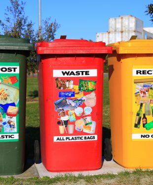 Three brightly colored waste bins placed where they can easily be found and used .