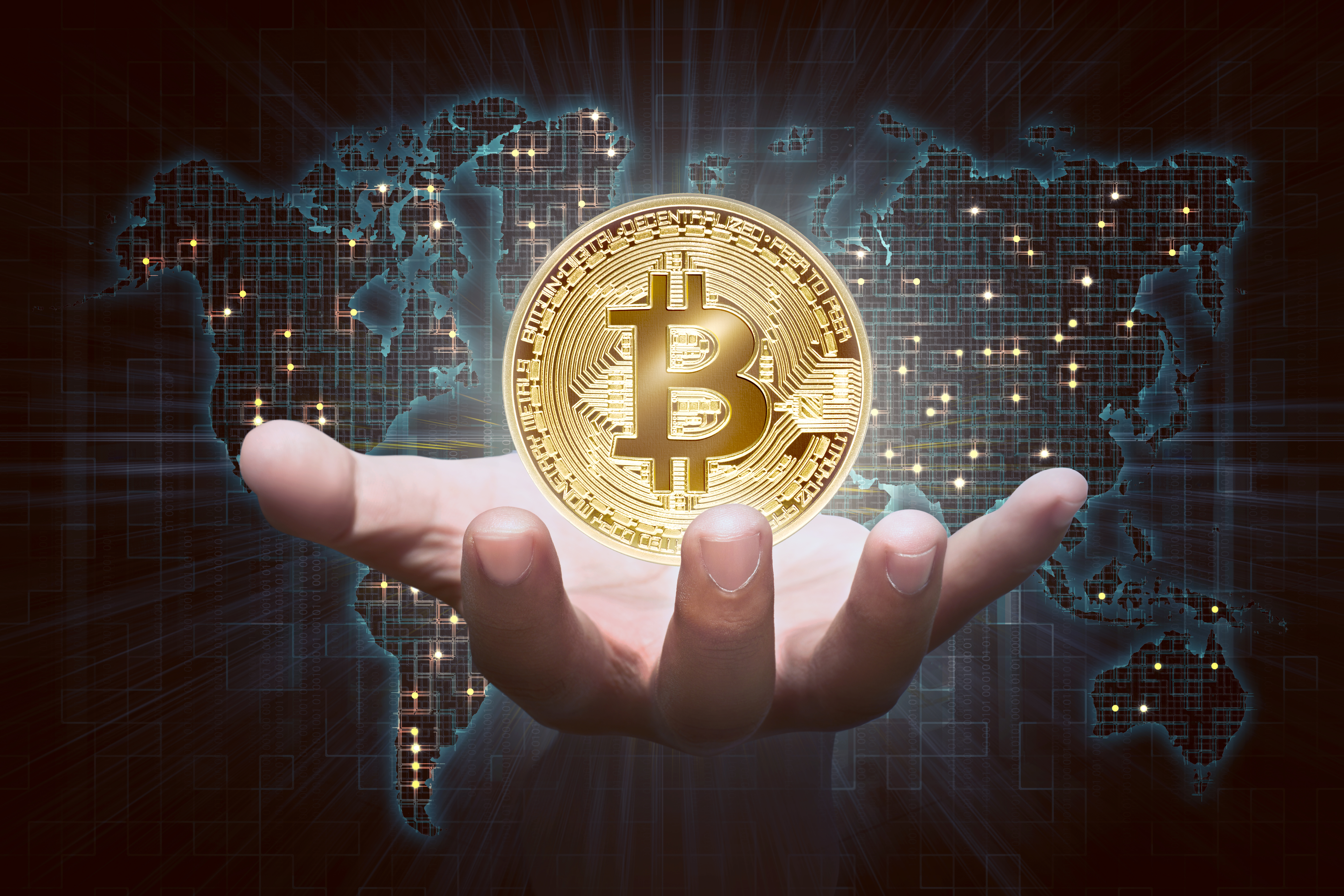 male hand showing golden bitcoin as virtual money on digital world map background