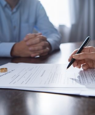 partial view of couple at table with divorce documents