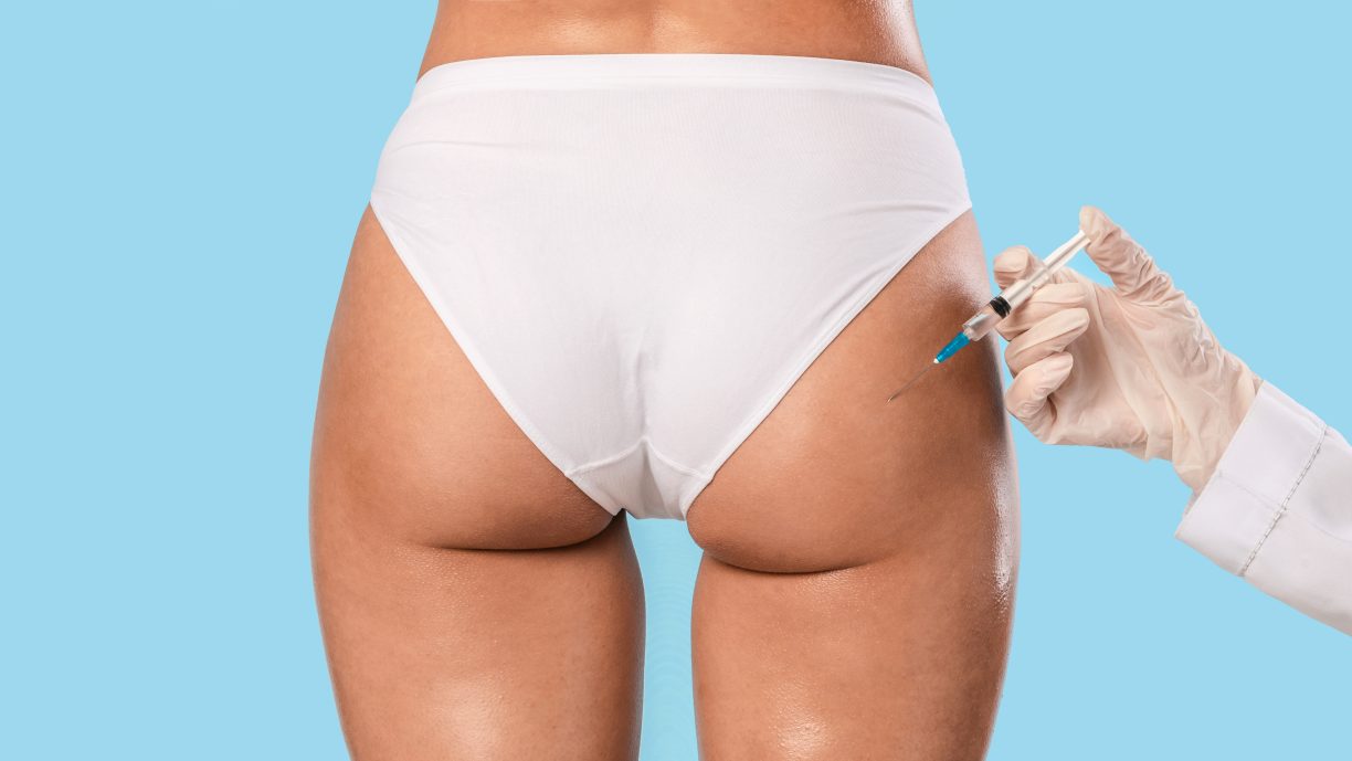 Woman having butt lifting treatment at beauty salon