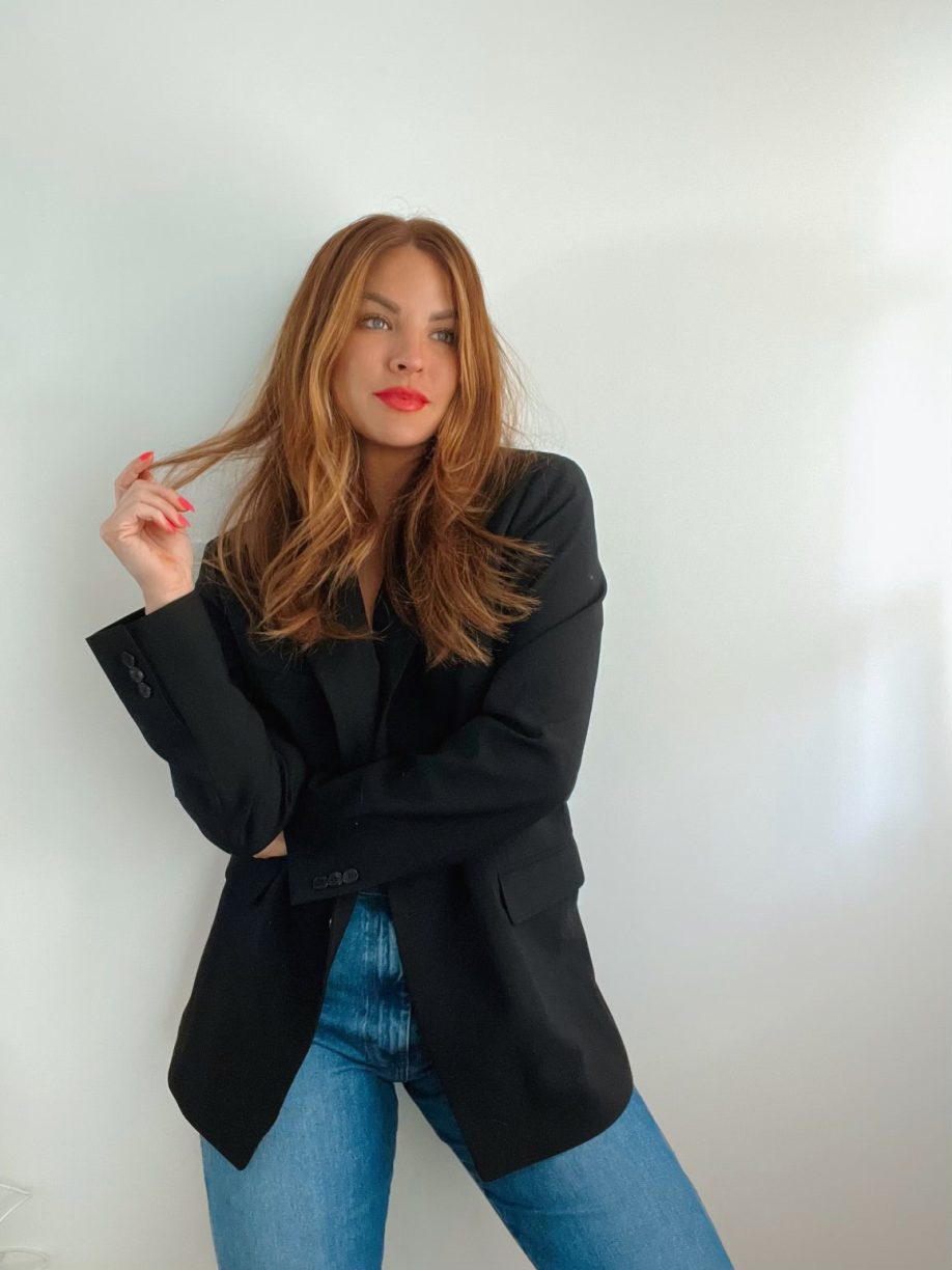 Woman in an oversized blazer with jeans and red lipstick