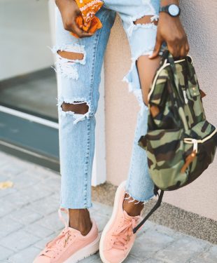 Woman leaning on wall carry camouflage backpack