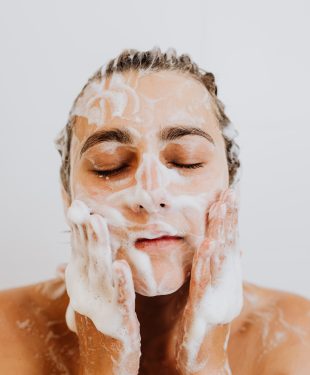 Woman washing face with foam