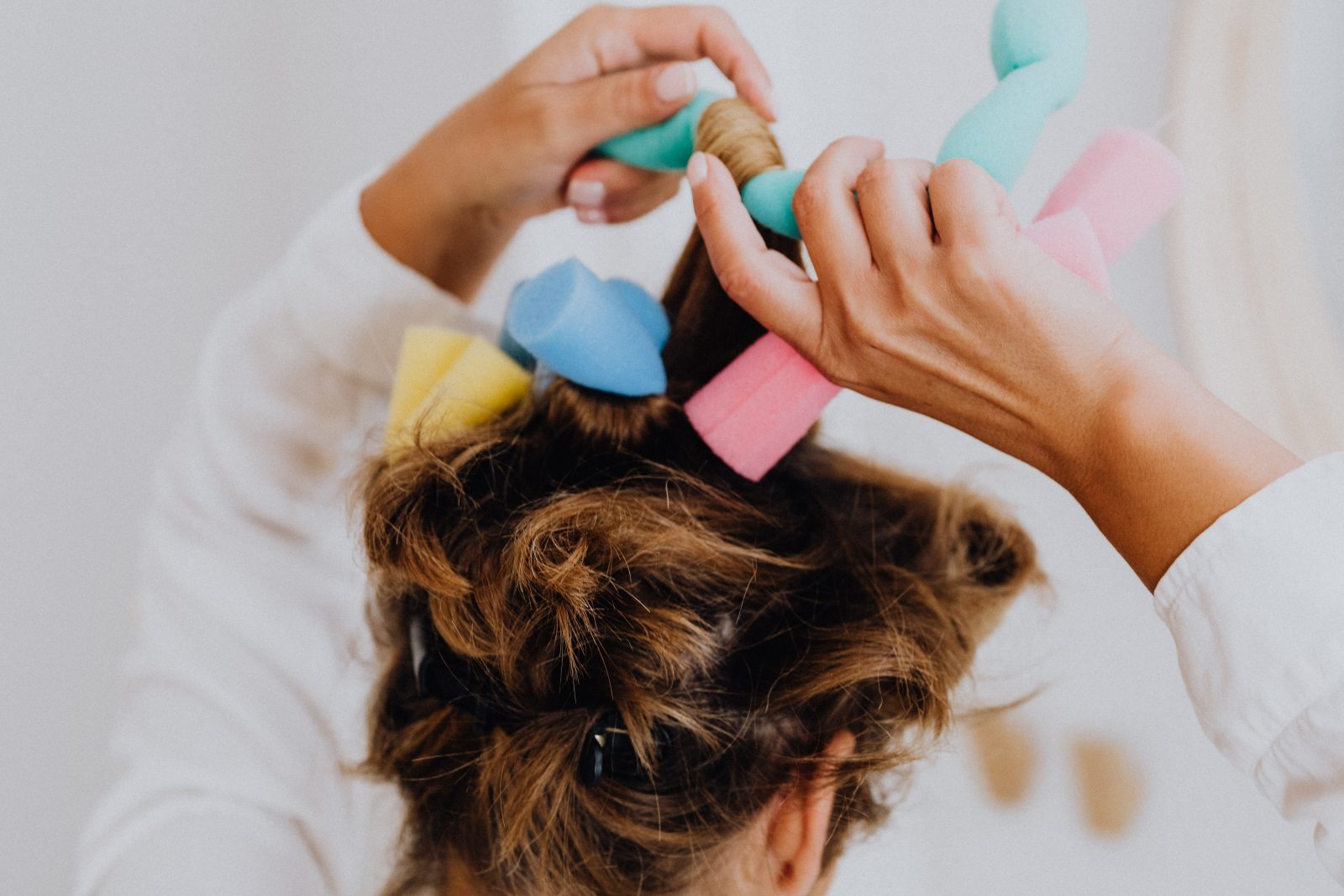 A woman putting curlers in her hair