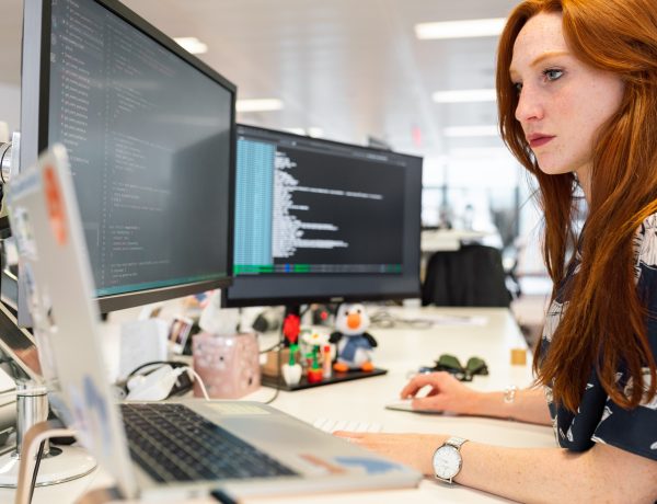 Female software engineer codes at computer