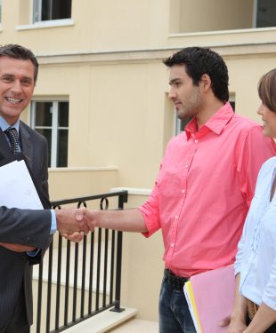 Couple shaking the hand of a real estate agent
