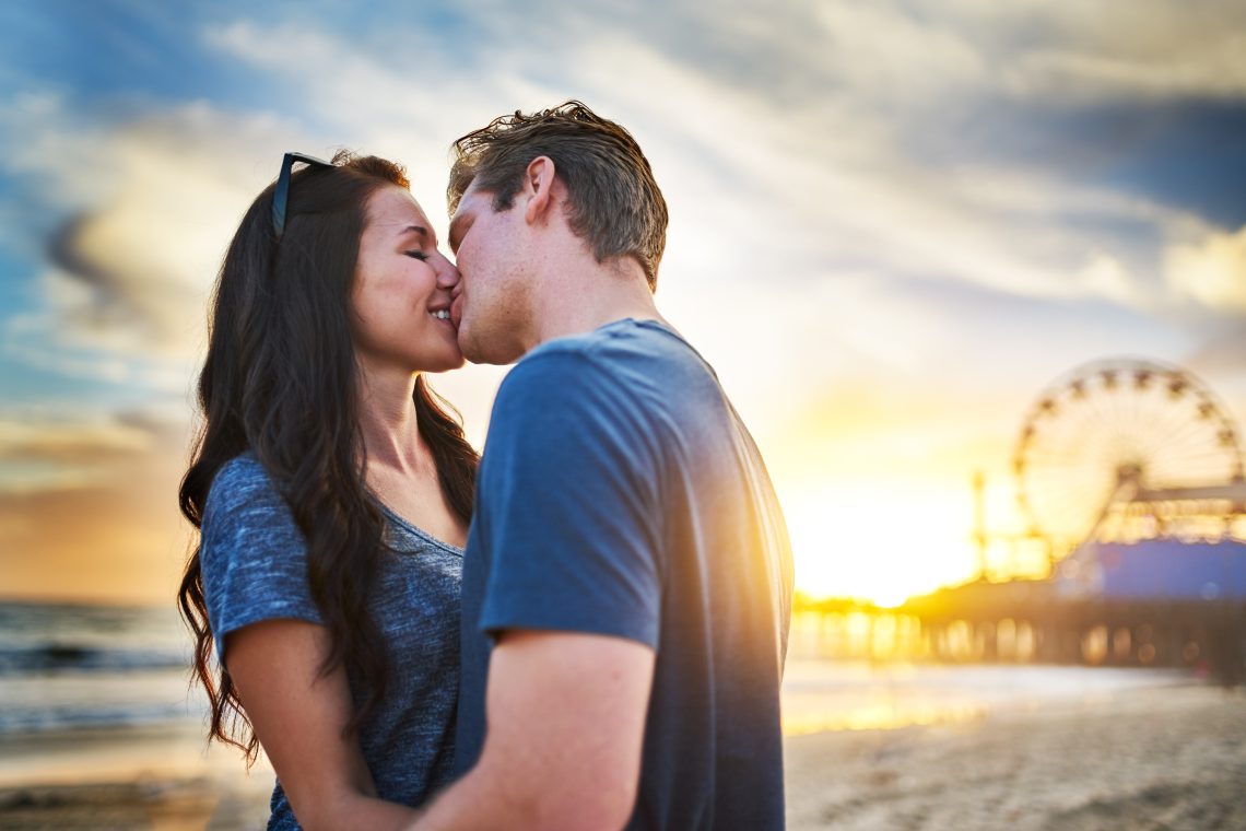 happy couple kissing on beach